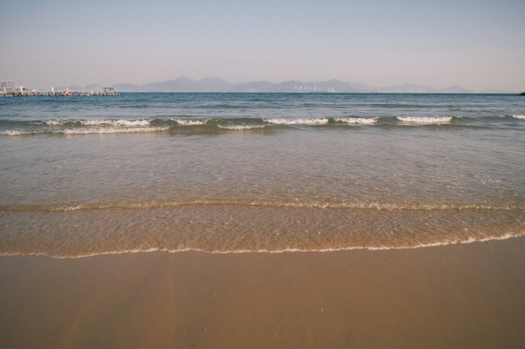 Waves rolling onto a sandy beach at the sea